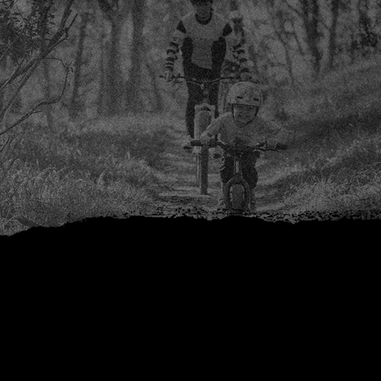 Child and parents riding down bike path